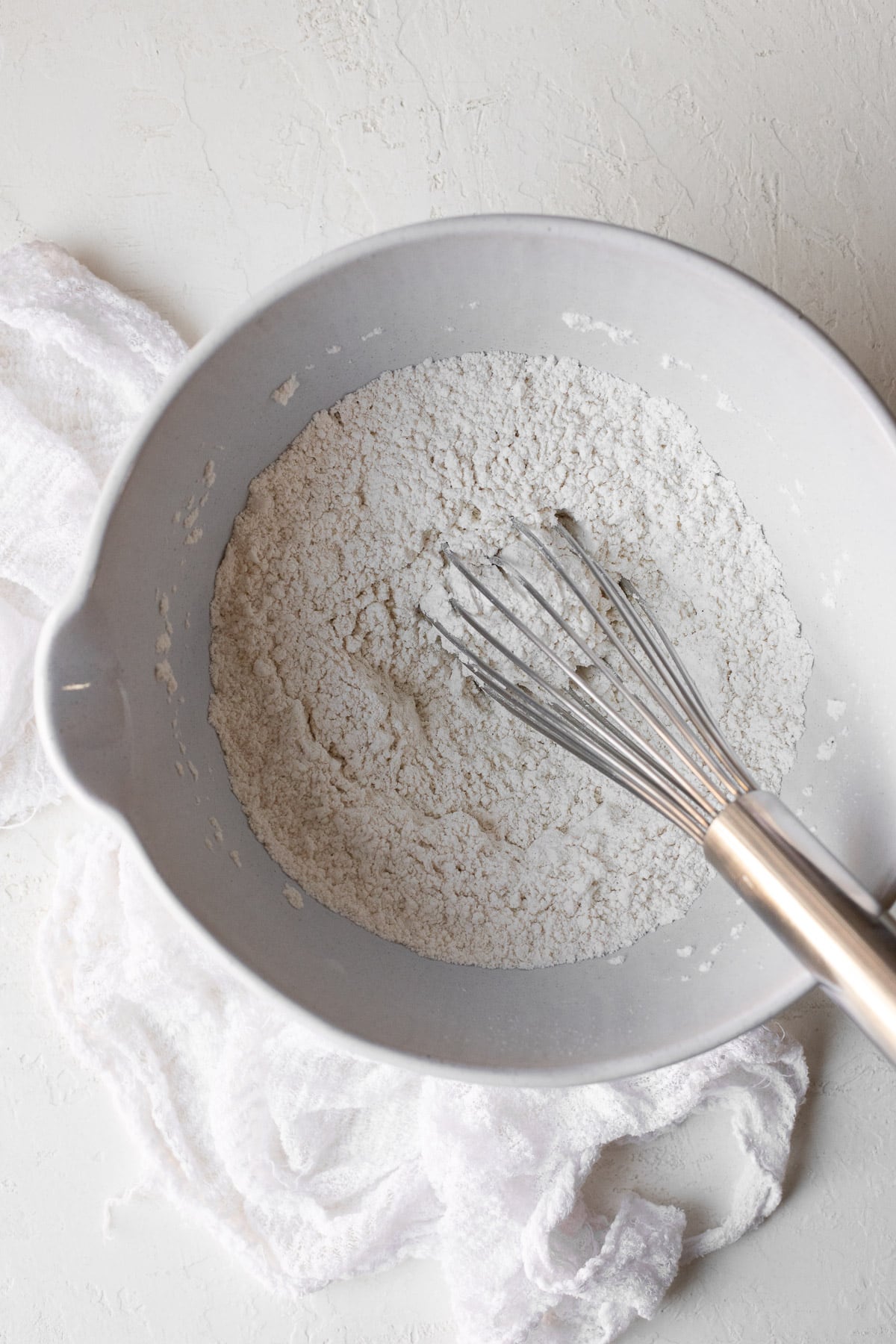 Flour, salt, baking powder, and baking soda whisked together in a bowl.