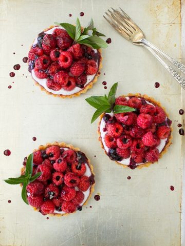Whole Wheat Berries and Cream Tartlets | Mini tarts with a light, shortbread-like crust, filled with sweet berry whipped cream and topped with plenty of fresh, juicy berries. | www.brighteyedbaker.com