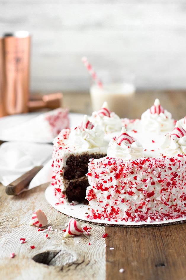 Boozy Chocolate Peppermint Layer Cake with Peppermint White Chocolate Frosting - A rich and moist chocolatey cake studded with pepperminty candy cane kisses and wrapped in a creamy, vodka-spiked peppermint white chocolate frosting. | www.brighteyedbaker.com #TreatsWithTitos