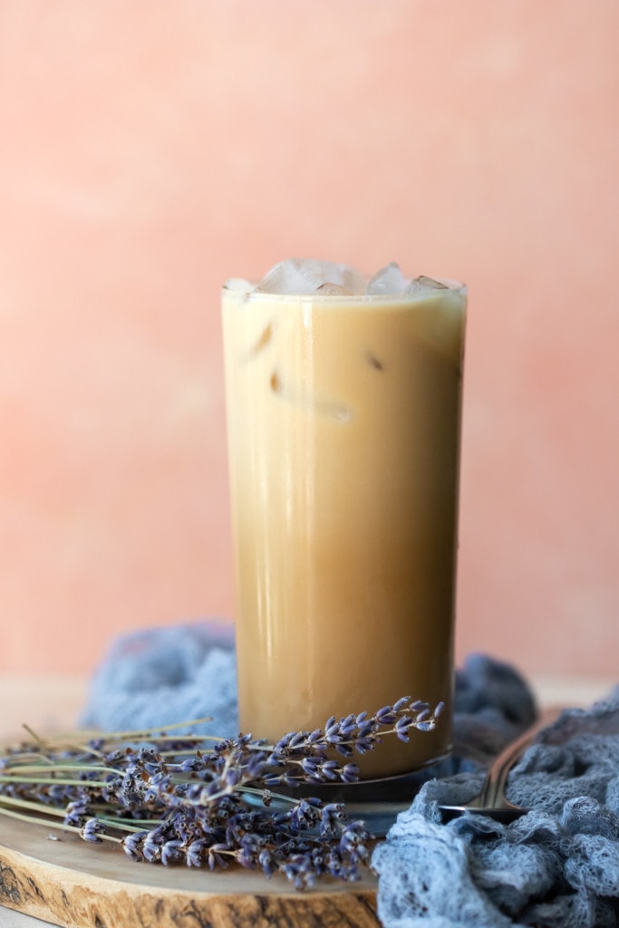 Iced Coffee on a wooden serving board, surrounded by a grey linen and dried lavender.
