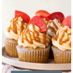 Front-facing view of cupcakes on a plate with text overlay reading "Salted Caramel Apple Cupcakes {gluten-free}".
