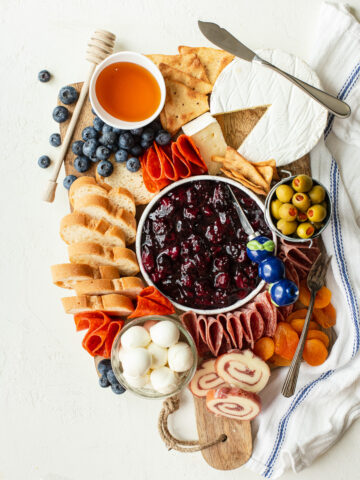 Charcuterie board with a variety of meats, cheeses, crackers, and bread, plus homemade fruit compote.