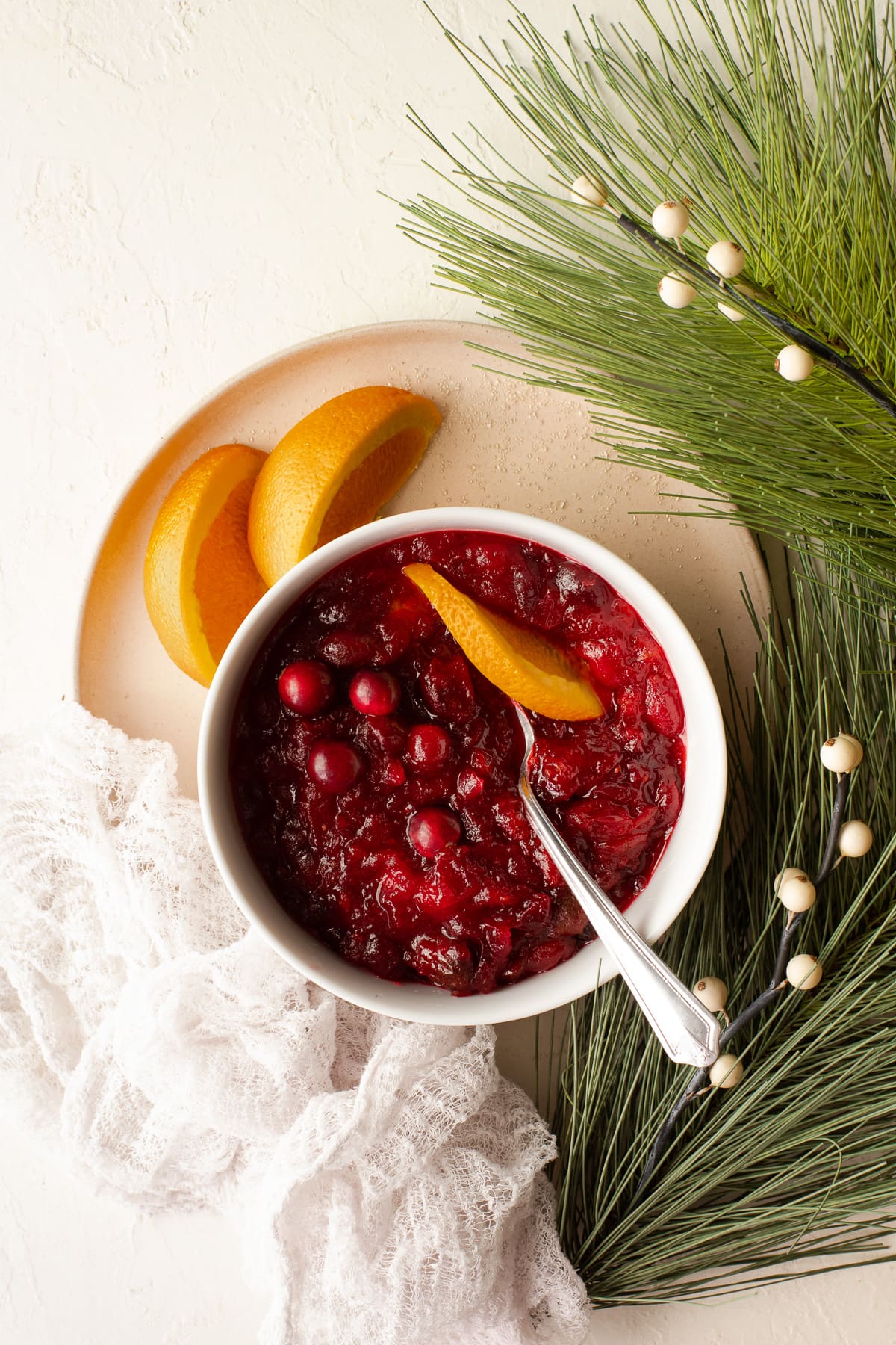 Bowl of homemade cranberry sauce garnished with an orange peel.