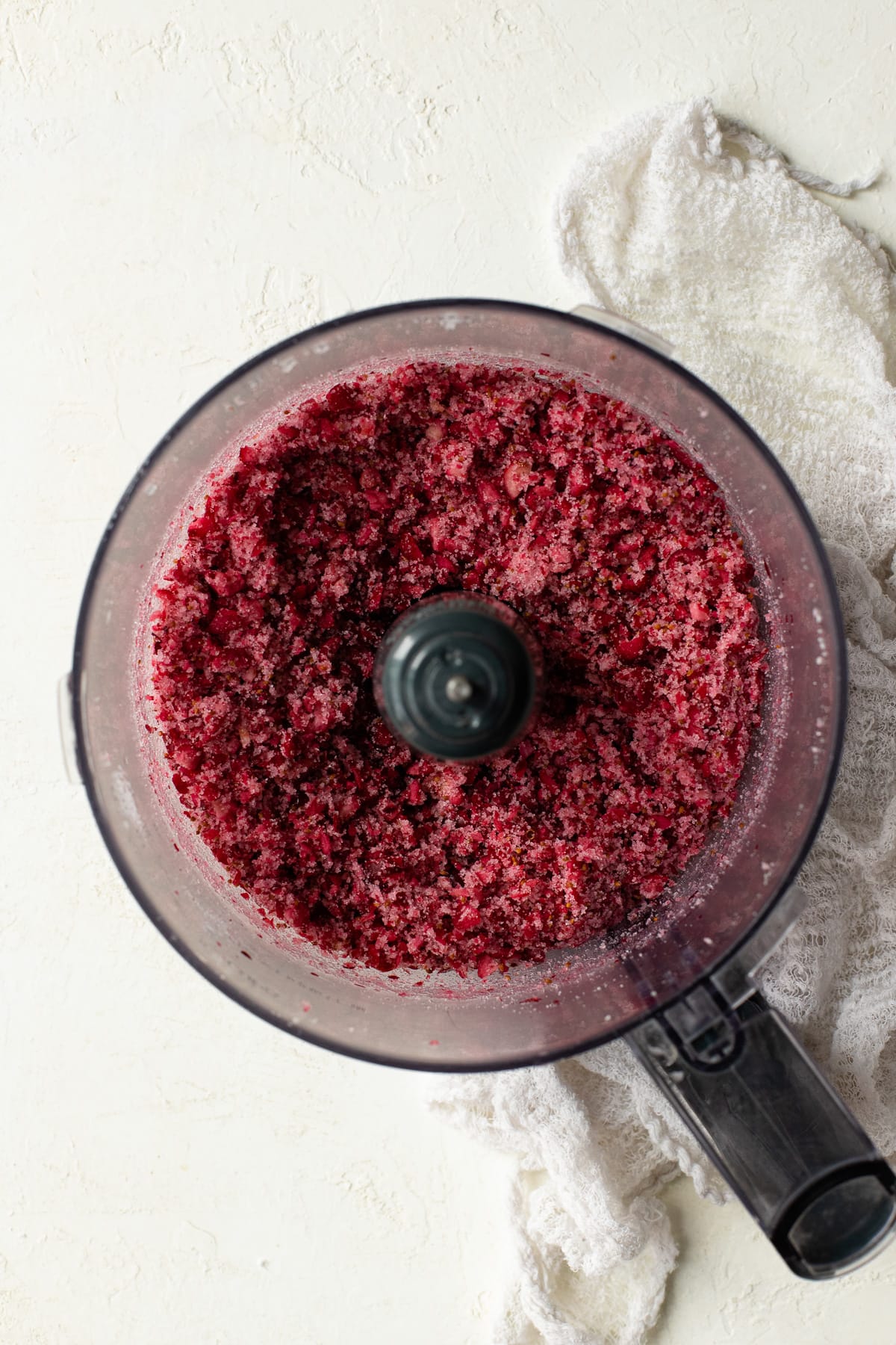 Frozen cranberries processed with sugar in a food processor.