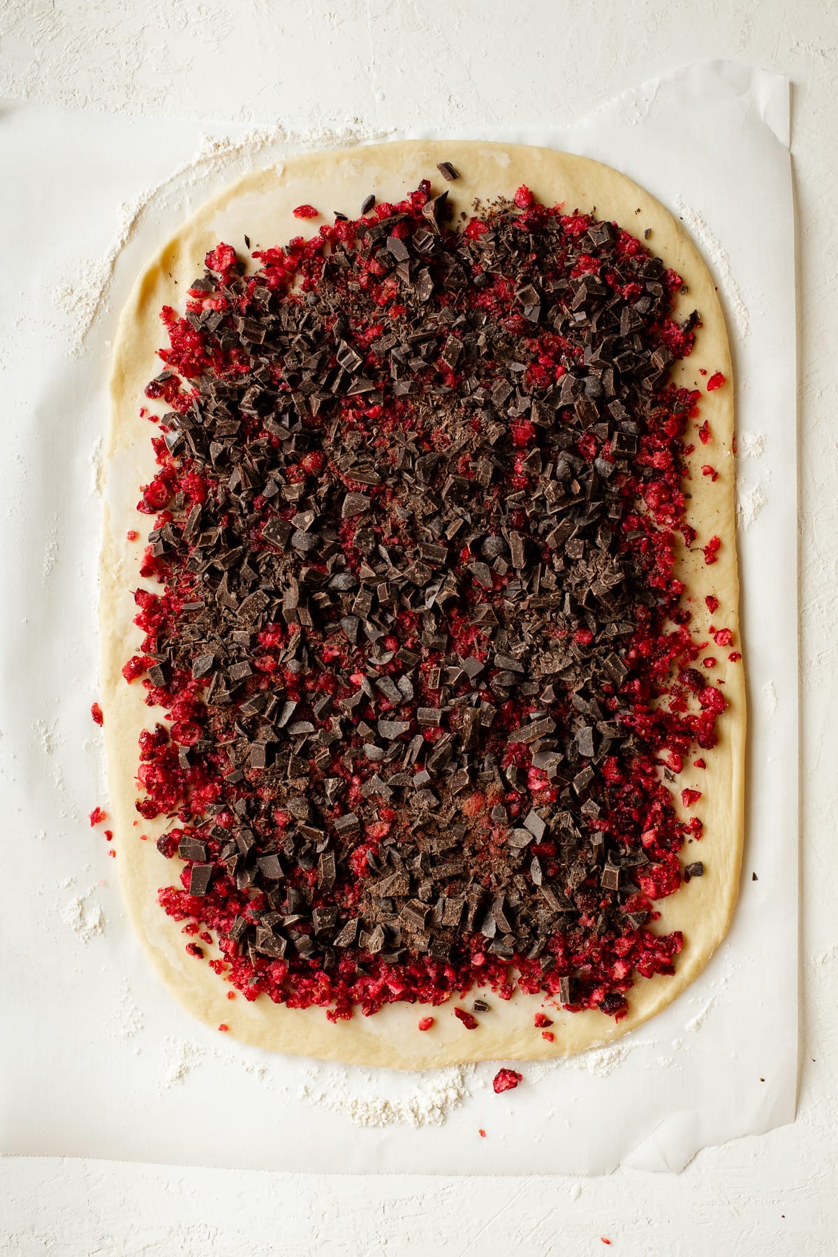 Brioche dough rolled out and topped with a cranberry-chocolate mixture.