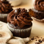 Dark chocolate cupcake topped with whipped chocolate ganache and a chocolate espresso bean.