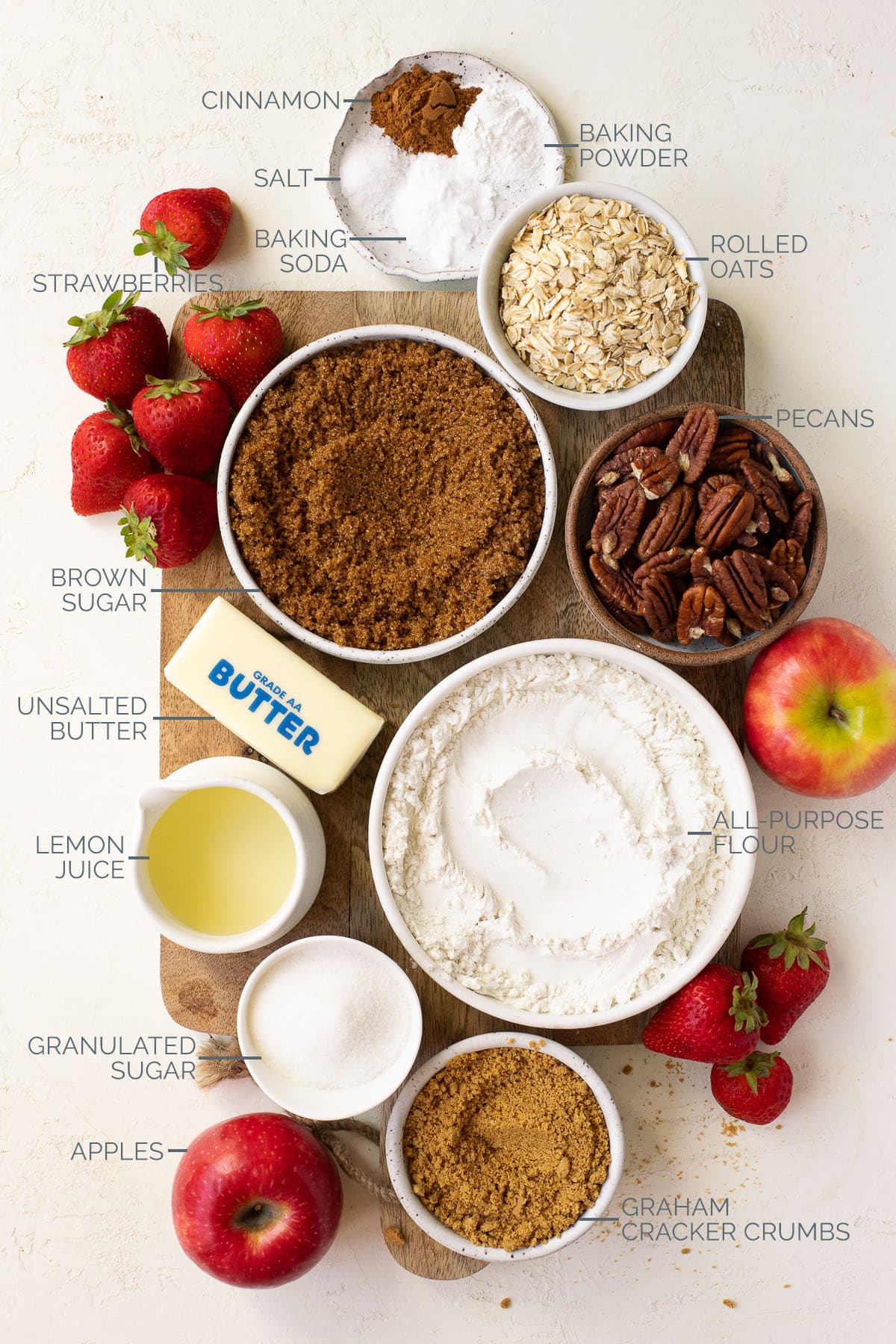 Labeled ingredients needed to make a strawberry and apple crumble.