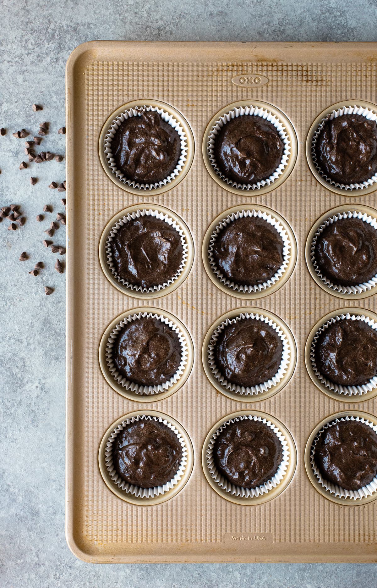 Chocolate cupcake batter in a muffin pan.