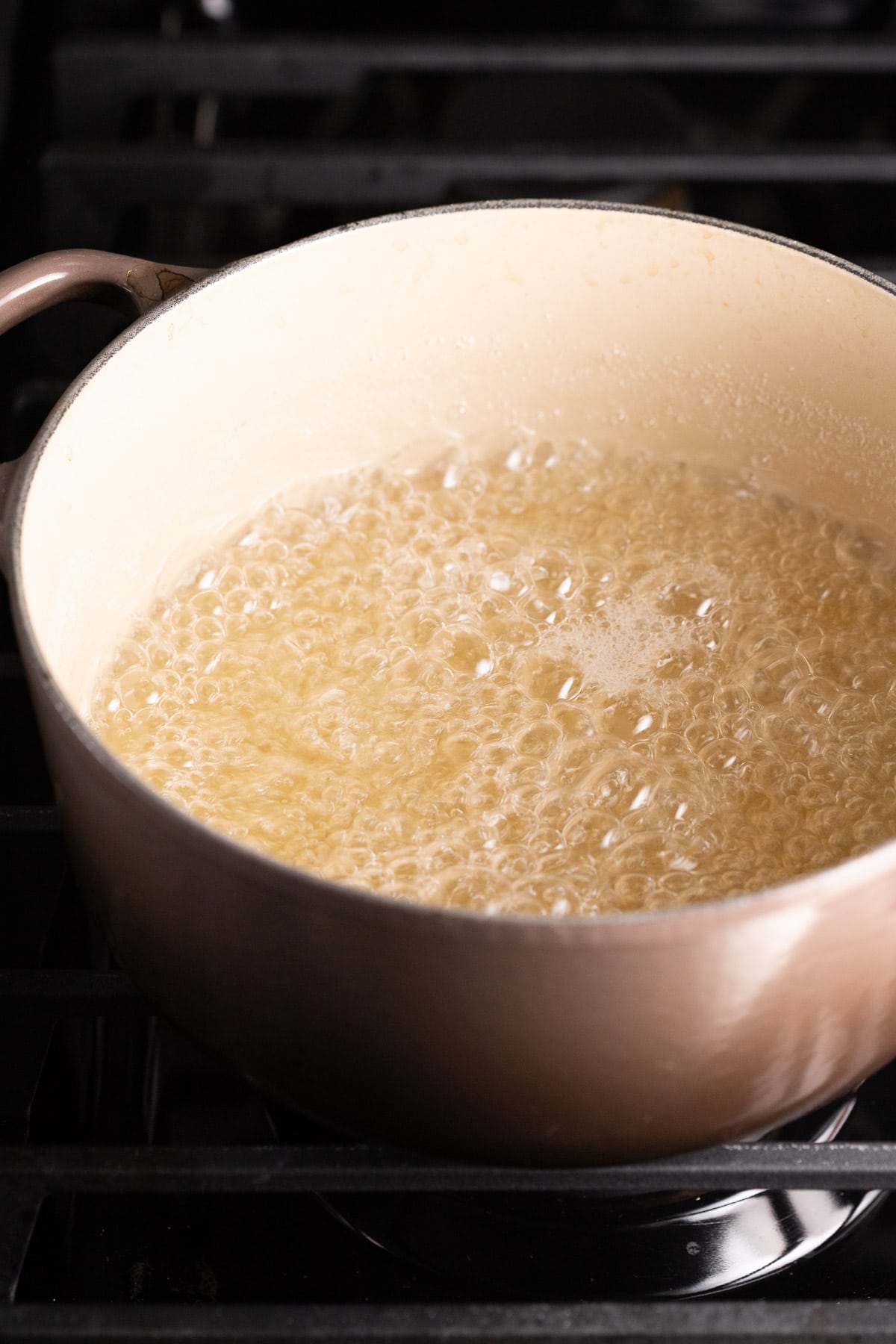 Sugar and water simmering in a pot on the stove.