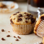 Close up of a muffin with iced coffee in the background.
