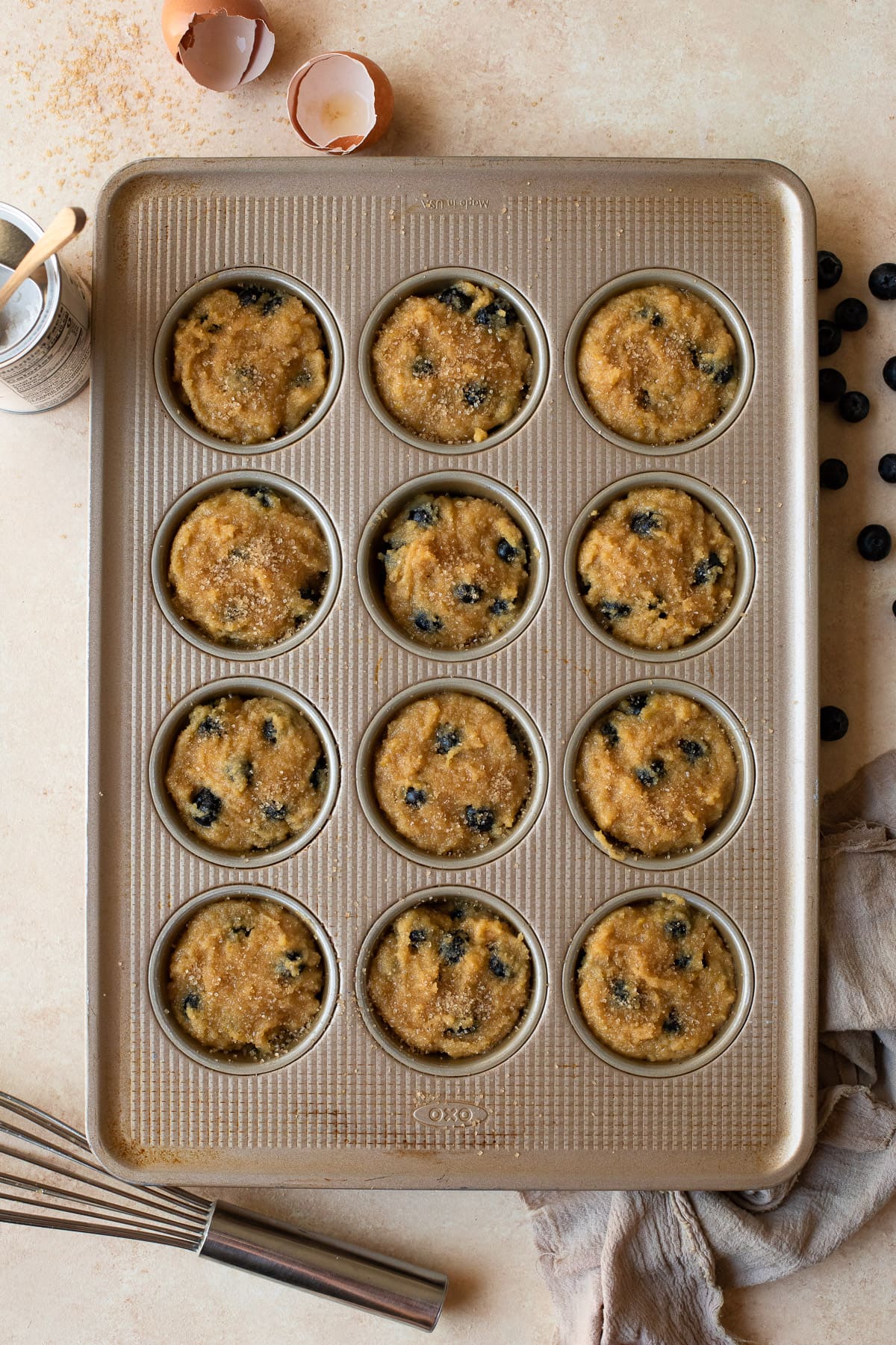 Blueberry almond flour muffin batter in a muffin pan.