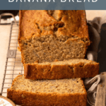 Banana bread with two slices cut on a wire cooling rack. Text overlay reads "Oat Flour Banana Bread".