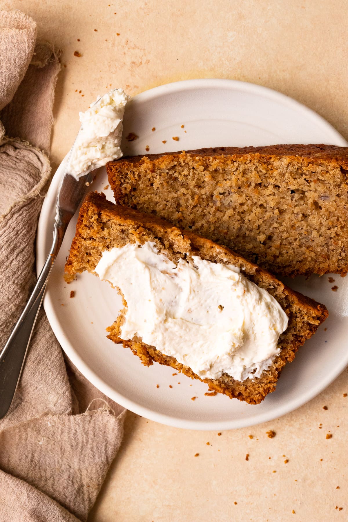 Sliced banana bread topped with whipped cream cheese.