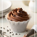 A small bowl filled with piped chocolate whipped cream, with a piping bag to the side. Text overlay reads "Chocolate Whipped Cream".
