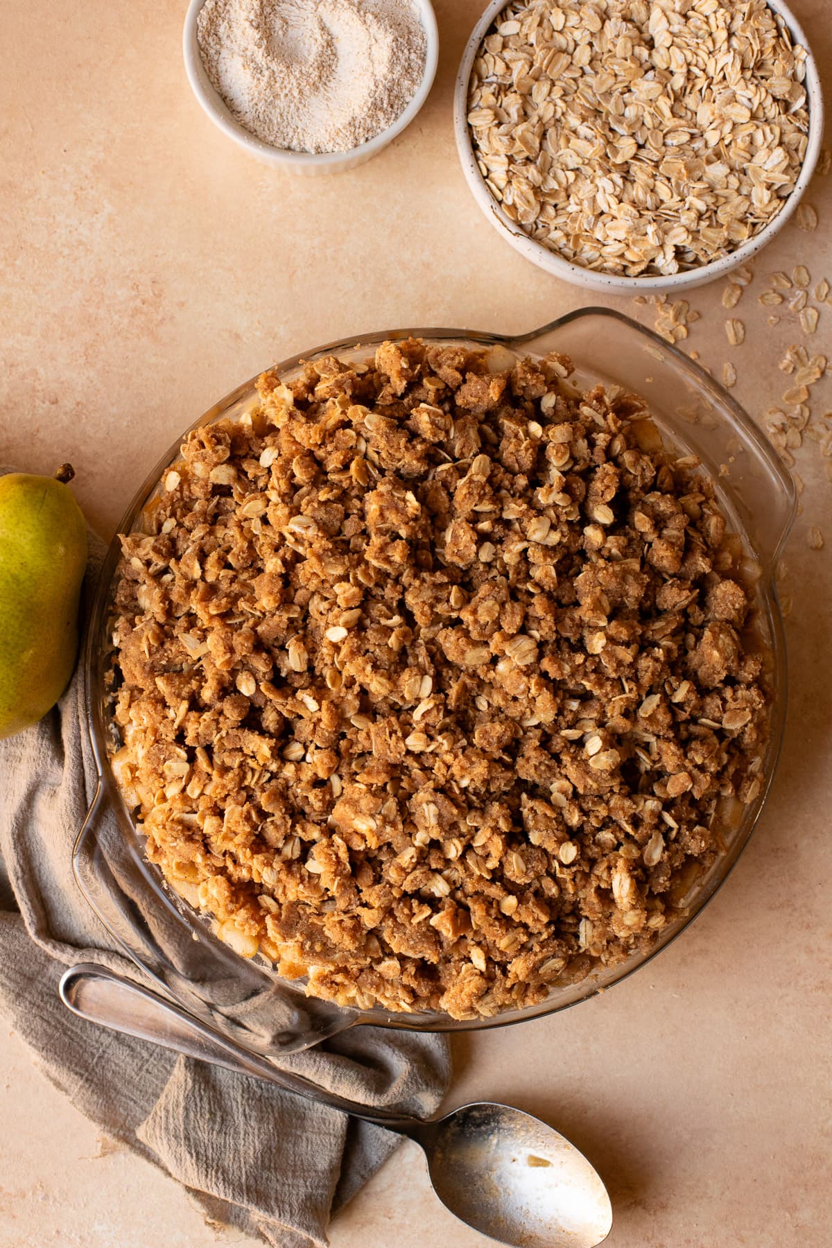 Unbaked crumble in a glass pie dish.