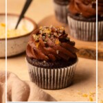 A cupcake in the foreground, two cupcakes in the background, and text overlay reading "Chocolate Orange Cupcakes".