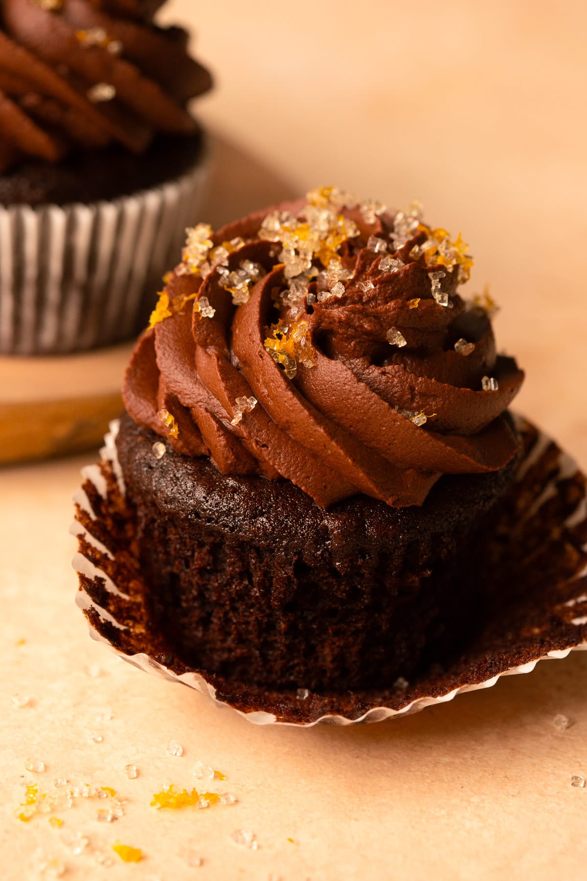 Close up of a chocolate orange cupcake with the paper lined peeled back.