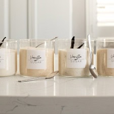 Four different variations of vanilla sugar in jars, made with vanilla extract, vanilla beans, or vanilla paste.