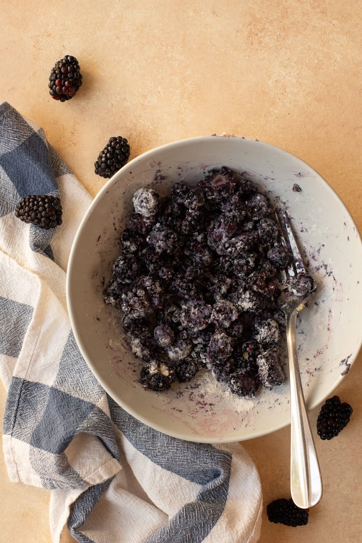 Fresh blackberries tossed with flour in a bowl.