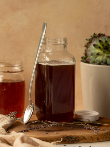 Syrup in a glass container with a spoon.