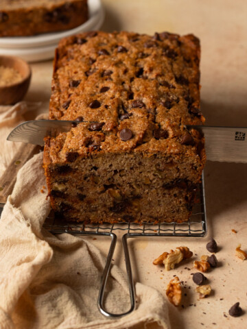 A loaf of banana bread being sliced.