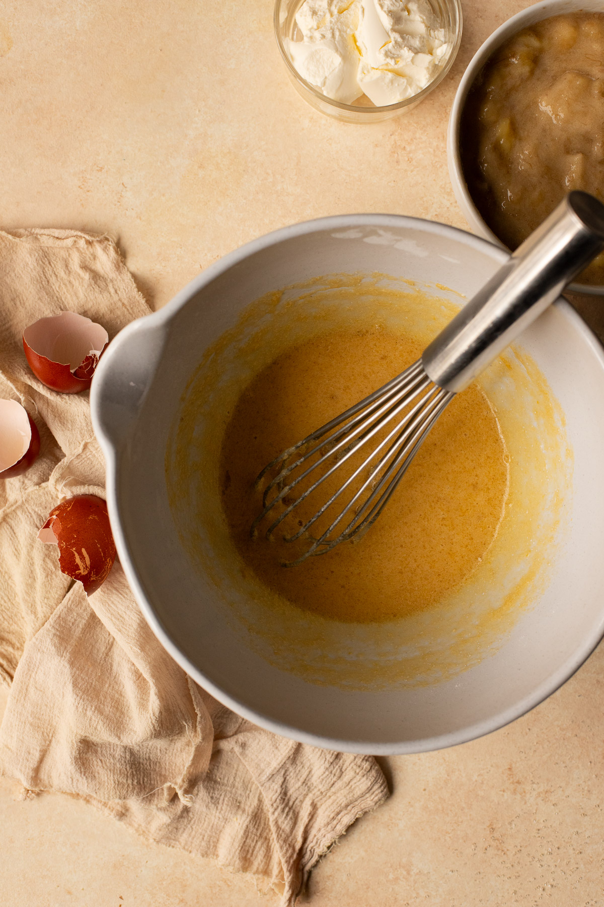 Melted butter, sugar, and eggs whisked together in a bowl.